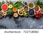 Healthy food clean eating selection: fruit, vegetable, seeds, superfood, cereals, leaf vegetable on gray concrete background copy space