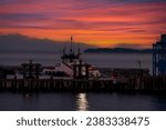 Small photo of Ferry boat docking at an island in the Salish Sea during a dramatic sunrise. The Whatcom Chief services Lummi Island commuters traveling to the mainland. Washington, USA.