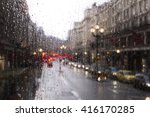 blurred view of road traffic in London on a rainy day through the bus window. raindrops on the glass window of the bus.