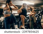 Fit friends doing high knees workout in a gym with fitness instructor.