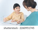 Small photo of Asian woman teaching little girl. Mother and daughter. Cram school. Tutor.