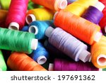 Multicolor sewing threads on wooden background
