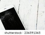 Broken iPhone on wooden background