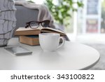 Cup of coffee with books on table in room