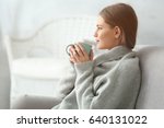 Beautiful young woman drinking tea while resting at home