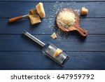 Wooden board with cheese and grater on table