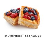 Delicious puff pastries with berries on white background
