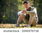 young asian man sitting on... | Shutterstock . vector #2040370718