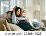 asian adult daughter and senior father enjoying conversation and good time at home