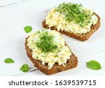 Small photo of Egg salad over brown bread with garden cress. White background. Homemade spread made from eggs, mayonnaise and mustard.