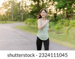 Fit young Asian woman jogging in park smiling happy running and enjoying a healthy outdoor lifestyle. Female jogger. Fitness runner girl in public park. healthy lifestyle and wellness being concept