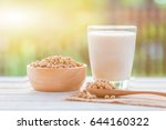 Soy milk in glass and soy bean on spoon it on white table background with lighting in the morning,healthy concept.