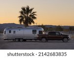 Small photo of Tecopa, California, USA - March 24, 2022: image of an Airstream Trailer and pickup truck shown in the Mojave Desert at dawn.