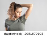 Excessive sweating problems. Young woman with her arm raised with her armpits sweat.