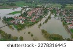 Small photo of AERIAL: Autumn flooding around rural village with large areas of muddy floodwater. River floods came dangerously close to residential buildings in countryside after abundant rainfall in fall season.