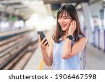 Young Asian woman passenger listening music via smart mobile phone in subway train when traveling in big city,japanese,chinese,Korean lifestyle and daily life, commuter and transportation concept