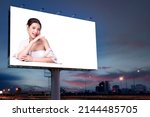 Small photo of Portrait of beautiful charming young Asian woman posing facial and sitting with white table advertise on billboard blank for outdoor advertising poster or blank billboard for advertisement.