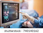 Electrocardiogram in hospital surgery operating  emergency room showing patient heart rate with blur team of surgeons background  