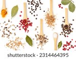 Different peppercorns in spoon, bay leaf, salt, turmeric and mustard seeds creative layout. Spices isolated on white background. Flat lay. Design element. Healthy eating and food concept