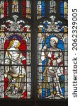 Small photo of Gloucester Cathedral, Gloucestershire, UK, October 18th 2021, The East window also shows St Cecilla or possibly St Dorothy with a crown of red roses, and St George and with red cross on his shield.