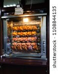 Small photo of Showcase of selling an oven with grilled chicken grill in a small street shop in a busy place at the exit of the Moscow metro. Grilled chickens are invariably in great demand.