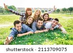 Small photo of Young people having fun together with self portrait on grass meadow - Youth life style concept with happy friends at picnic camping out side - Warm vivid filter with backlight contrast sunshine