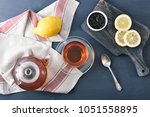 Small photo of black Bayh tea with lemon in glass teapot and glass tea mug - top view - flat layer