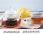 Small photo of black Bayh tea with lemon in glass teapot and glass tea mug