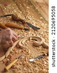 Small photo of Timber, wood processing. Joinery work. Wood carving with work tools close up. Hand of carver carving wood. Craftsman carving with a gouge