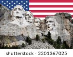 Small photo of Mt. Rushmore National Memorial Park in South Dakota with American flag in background. Sculptures of former U.S. presidents; George Washington,Thomas Jefferson,Theodore Roosevelt and Abraham Lincoln.