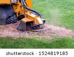 close up of a stump grinder machine, grinding up a tree stump into saw dust and mulch