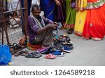 Small photo of HYDERABAD,INDIA-DECEMBER 19:Indian senior man keep guard of foot wear of devotees,who leave them, outside the temple,for money on December 19,2018 in Hyderabad