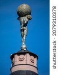 Small photo of Vilnius, Lithuania - May 11, 2021: Restored figure of Atlas upholding the vault of heaven on the cylindrical turret of Merchants Club, historic business center.