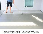Small photo of Worker and renovation work. To using roller painting mortar cement or finishing material for repair crack, skim coat or improvement surface of concrete pavement floor or slab for driveway or garage.