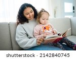 A babysitter black woman read book with little child girl