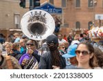 Small photo of NEW ORLEANS, LA, USA - MARCH 17, 2019: Selectively focused young man plays sousaphone in the midst of a seemingly oblivious crowd prior to annual Super Sunday parade