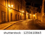 Narrow cobbled street in old medieval town with illuminated houses by vintage street lamps, Novy svet, Prague, Czech Republic. Night shot.