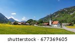 Graswang village with parish church, flowers and mountains in the background, Ettal, Bavaria, Germany