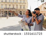 couple tourist in sightseeing in city using paper map and taking pictures with camera