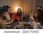 friends celebrating singing and playing guitar at home dinner party
