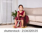 Asian cute little girl swinging riding toy horse, Smiling kid playing horse rocking chair at home in living room, Happy time to play during self kindergarten preschool