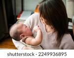 Small photo of Asian mom holding her crying little baby at home, Mother comforts little son or daughter newborn, Parent woman cuddling baby tenderness, cry after birth