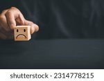 Small photo of Unsatisfied customer expressing dissatisfaction on a wooden block. Concept of bad product quality, low rating, and negative comment. The impact of unsatisfied customers on business reputation.