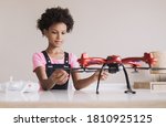 Little girl holding quadcopter. Child playing with drone at home. Education, home studying, children lifestyle, technology, science, future and people concept