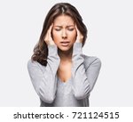 Young beautiful woman has headache, isolated on gray background. Exhausted girl portrait