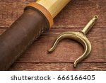Small photo of wooden oar and brass oarlock (rowlock) on rustic weathered wood background