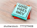 Good vibes only reminder - handwriting on a sticky note against grained wood