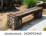 Small photo of A wooden bench, piece of wood, or railway sleeper with legs made from stones.