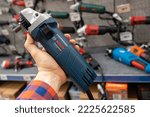 Small photo of Bosch angle grinders. A man in a hardware store chooses a new Bosch angle grinders. Angle grinders tool in hand closeup. Minsk, Belarus, 2022