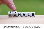 Small photo of Inhale,Exhale concept. Hand turns dice and changes the word "INHALE" to "EXHALE".